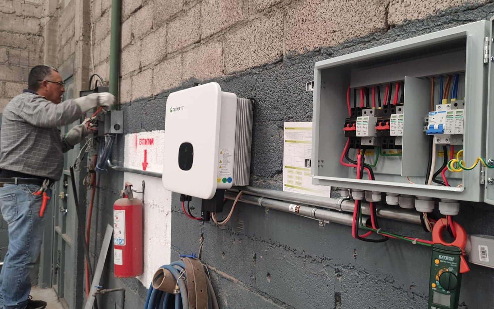 Técnico instalando inversor y gabinete de protecciones